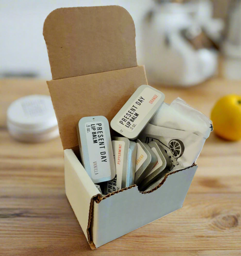 set of 5 lip balm tins in an opened paper board box