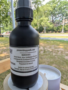 Black bottle with a label on a wooden surface outdoors ingredients list