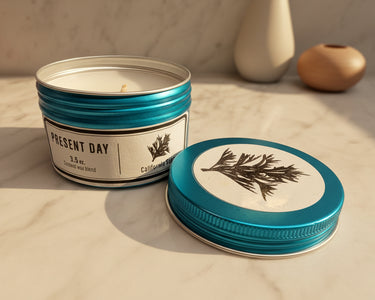 Candle in a metal tin with a blue lid on a marble surface