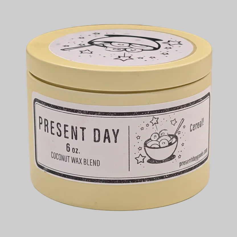 Yellow candle jar with 'Present Day' label on a white background