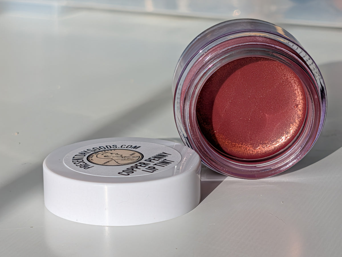 Open jar of blush with a white lid on a light background
