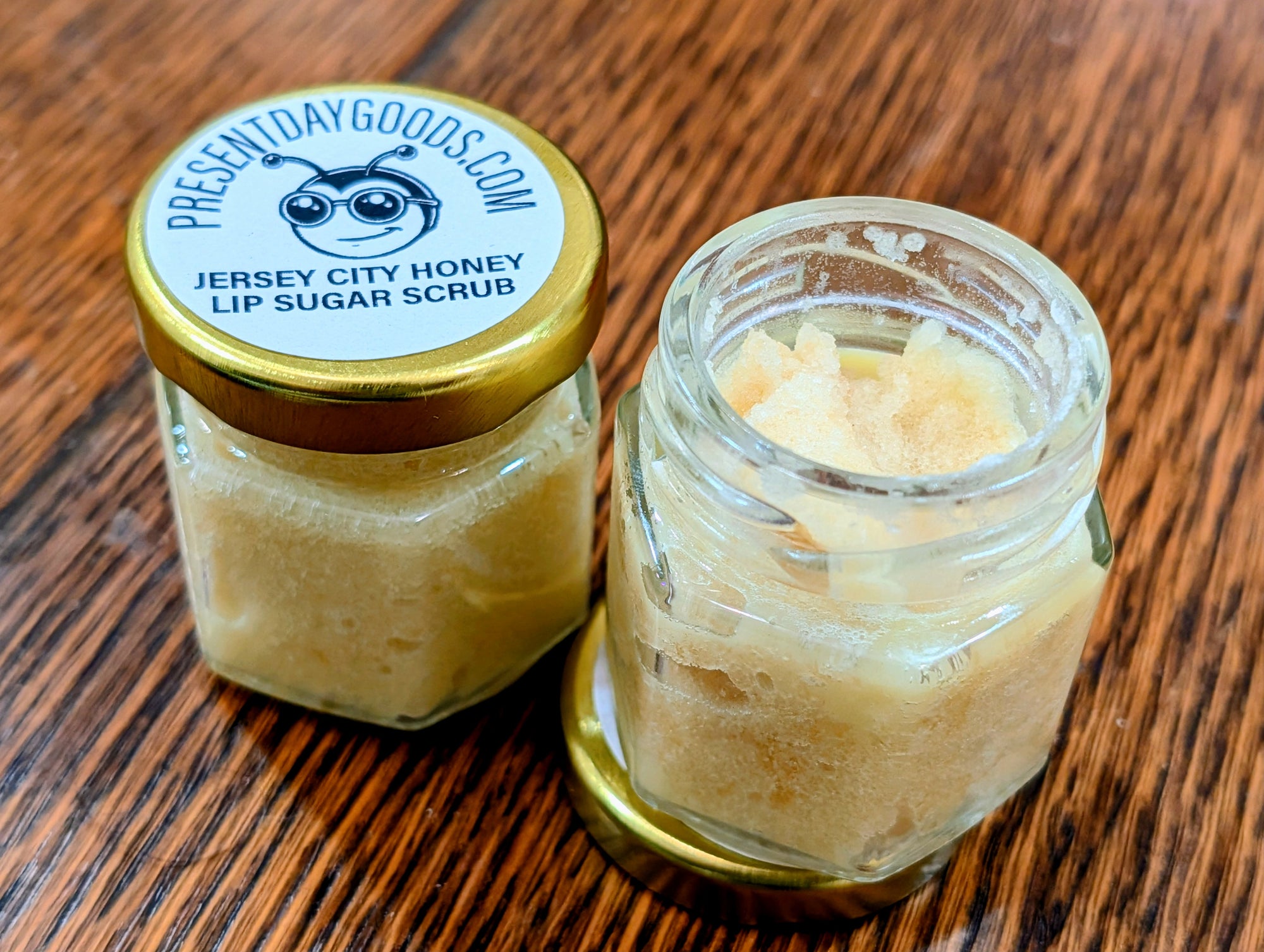 Two jars of Jersey City Honey Lip Sugar Scrub on a wooden surface with 'Present Day Goods' branding.