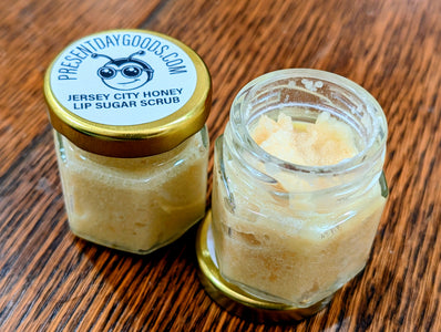 Two jars of Jersey City Honey Lip Sugar Scrub on a wooden surface with 'Present Day Goods' branding.