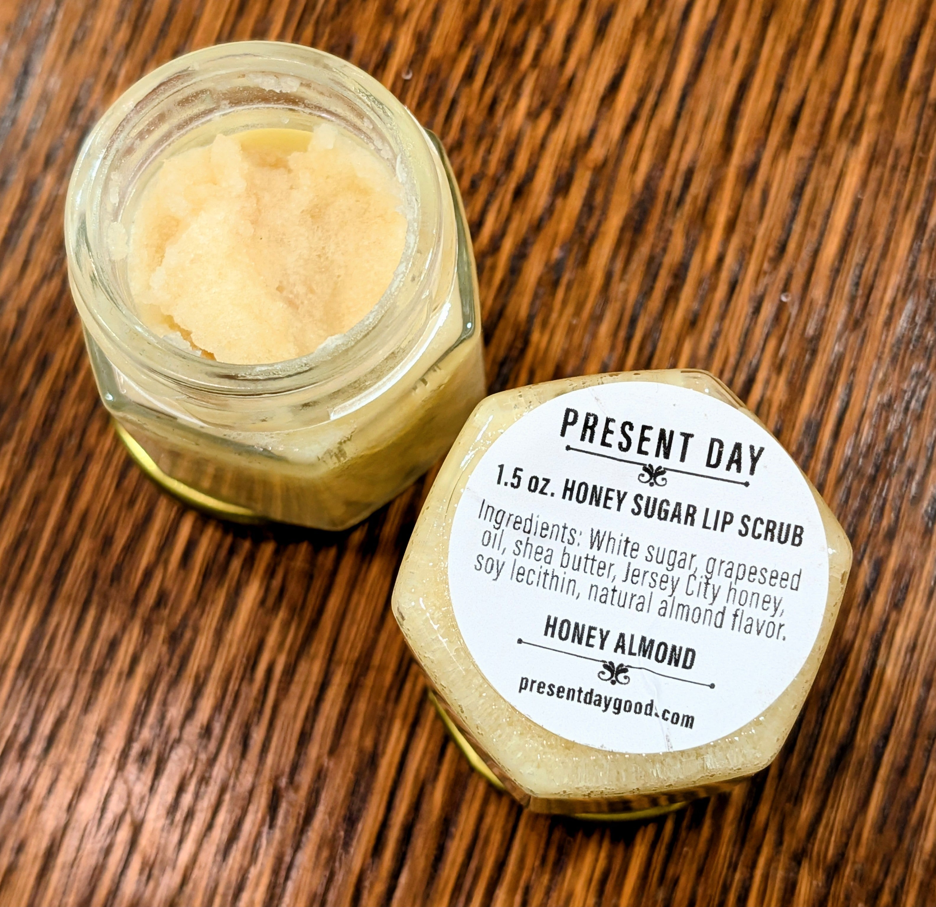 Honey sugar lip scrub jar with label on a wooden surface