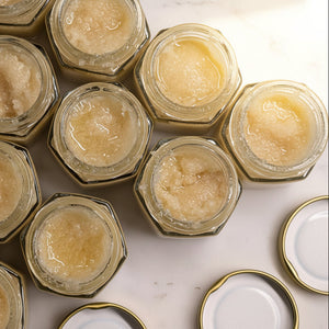 Hexagonal jars filled with lip sugar scrub on a marble table