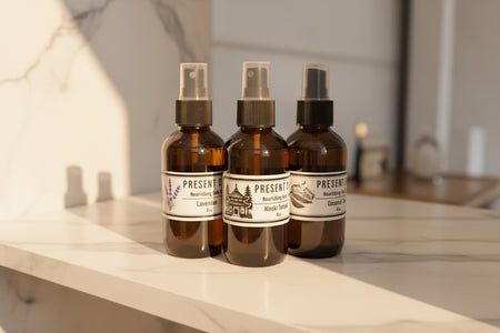 Bottles with black labels in a gold tray against a white wall.