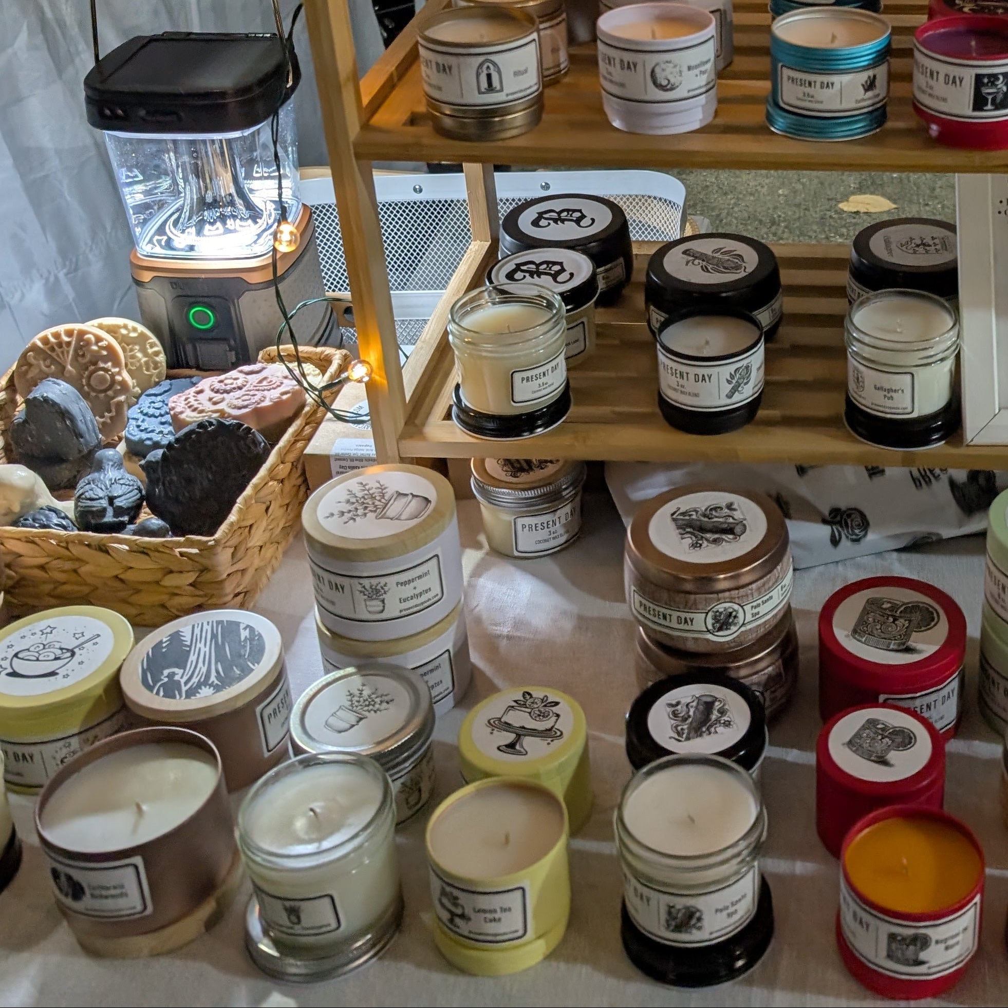 Display of various candles and decorative items on a wooden shelf.