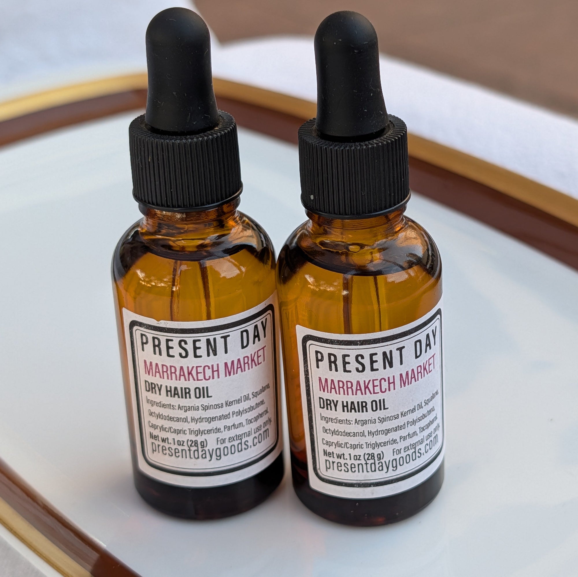 Two amber glass bottles of hair oil 