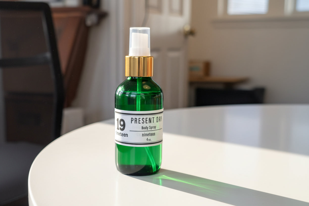 Two green spray bottles with gold caps and 'Present Day' labels on a white surface.