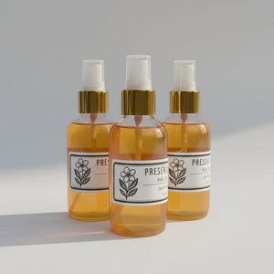 Bottles of Present Day Goods body spray products on a white background.