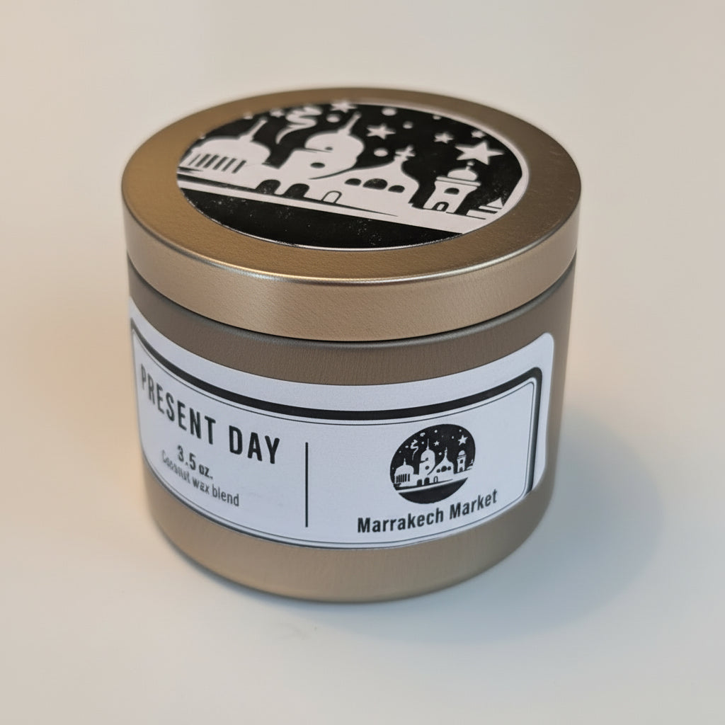 Candle in a tin with 'Present Day' and 'Marrakech Market' labels on a light background