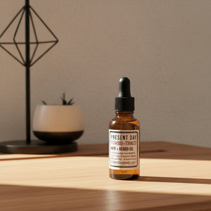 Bottles of Present Day Redwood + Tobacco Hair + Beard Oil on a shelf.