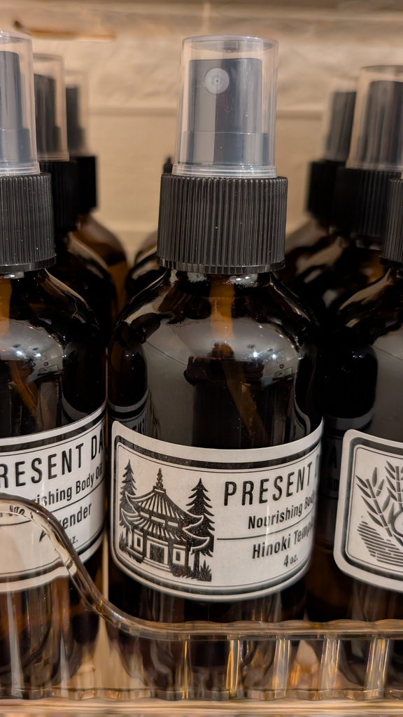 Bottles with black labels in a gold tray against a white wall.
