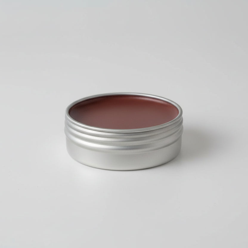 Metal tin with brown substance on a light background