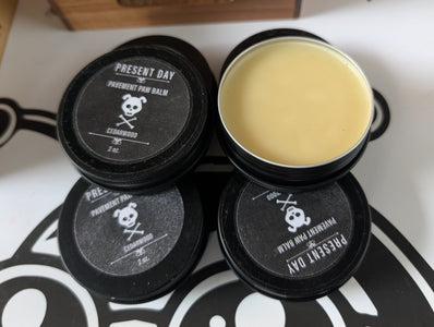 Black containers with a yellow substance on a patterned surface