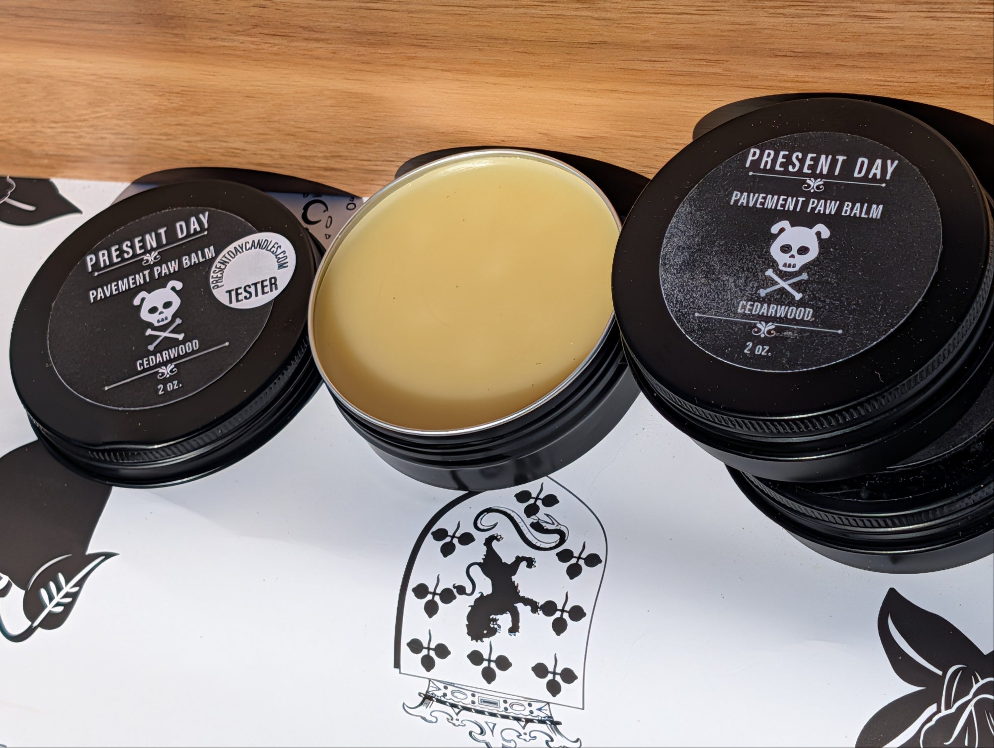 Pavement Paw Balm container with black lids on a white background with brand logos.