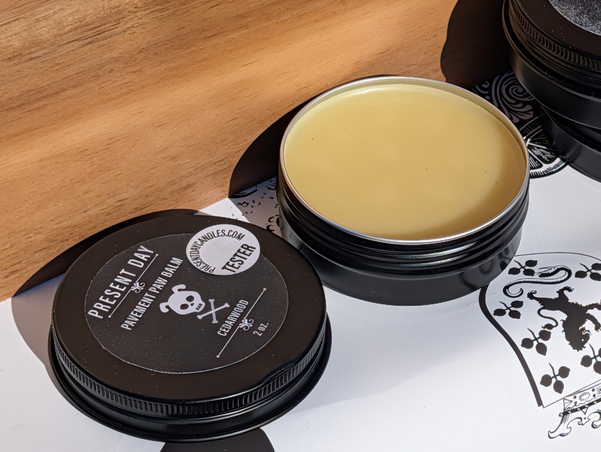 Black container with a yellowish substance on a white surface with a wooden background