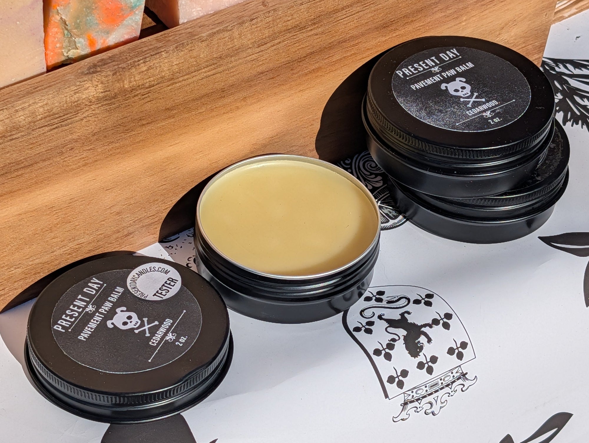 Wooden box with paw balm containers on a decorative surface.