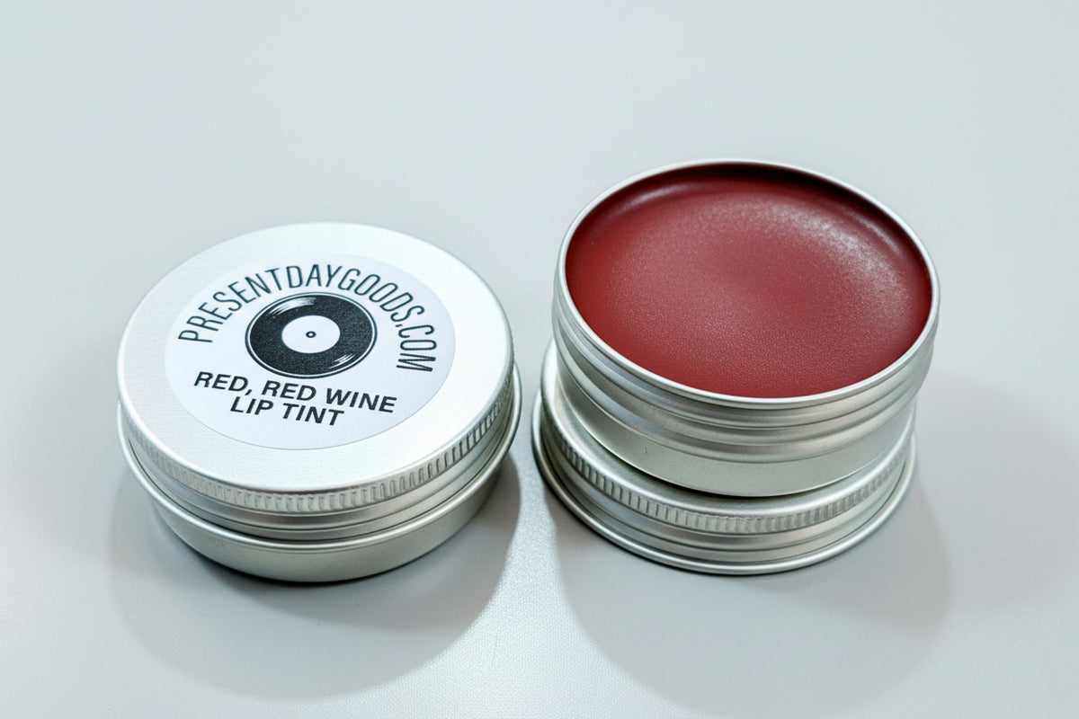 Red wine lip tint in a metal container on a wooden surface