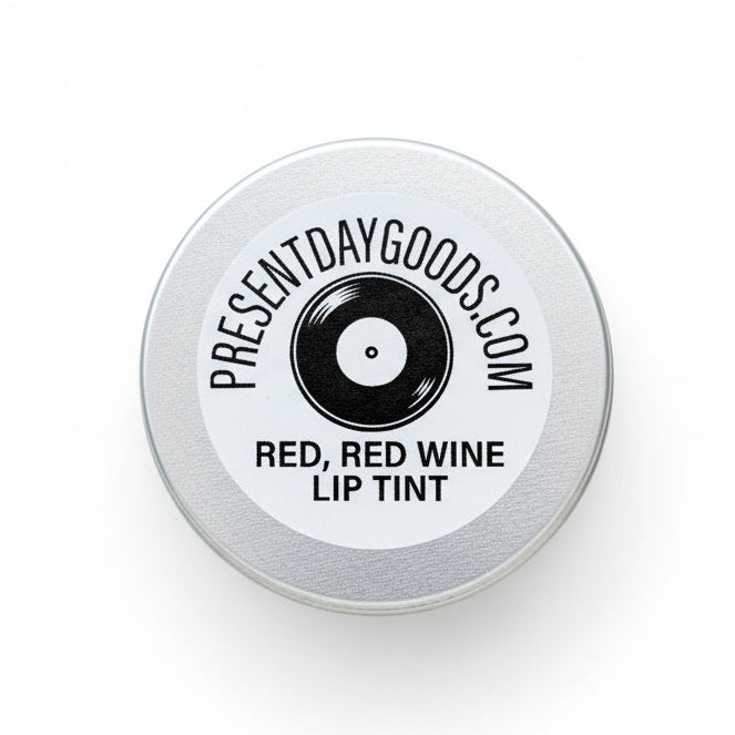 Lip tint container with 'Present Day Goods' label on a cosmetic counter