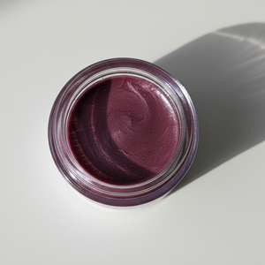 Jar of purple lip tint on a light gray background
