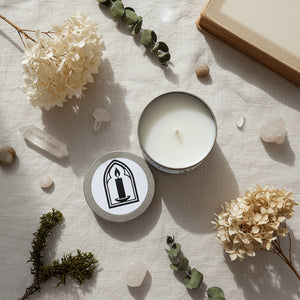Candle in a tin with a lid featuring a candle illustration on a white surface