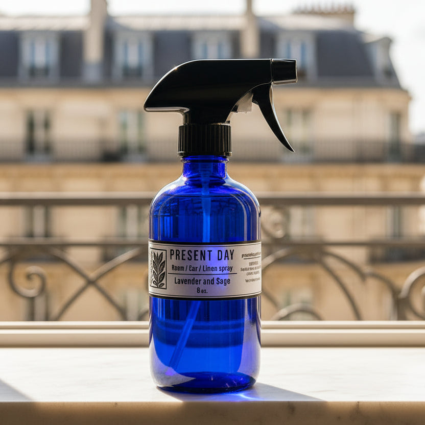 Blue spray bottle with black nozzle on a marble surface