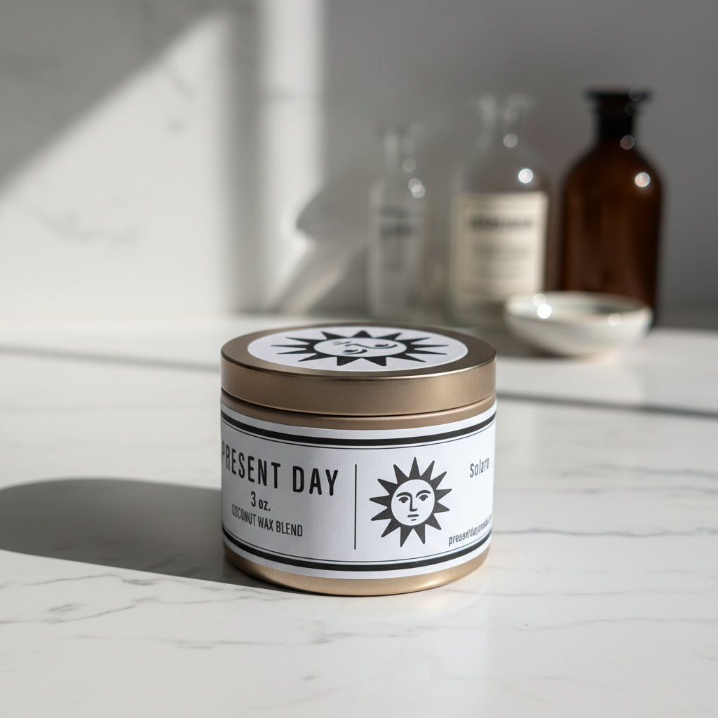 Candle jar with 'Present Day' label on a white surface