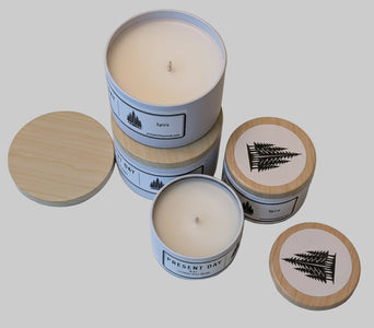 Set of candles with wooden print tin lids on a light surface