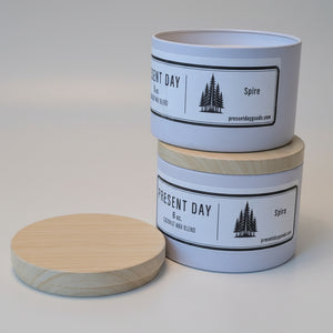 Two pine scented candles with labels on a white surface