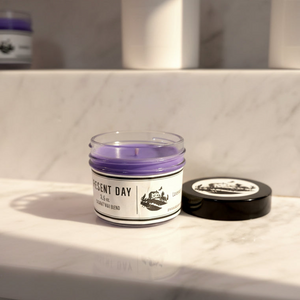 Candle in a glass jar with a label on a marble surface