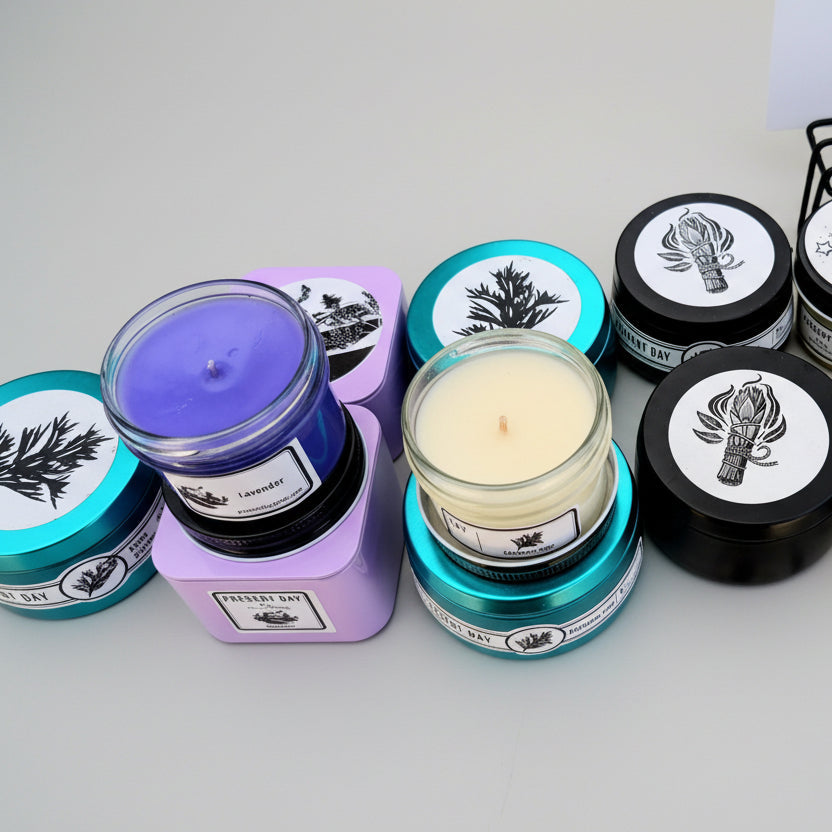 Collection of various candles with different colored containers and labels on a white background.