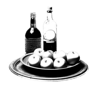Two bottles and a bowl of apples on a white background