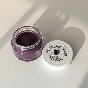 Purple lip tint jar with 'Present Day Goods' label on a white background