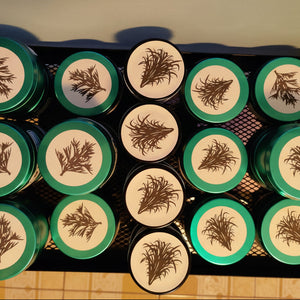 Set of cylindrical containers with labels arranged in a grid on a wooden surface.